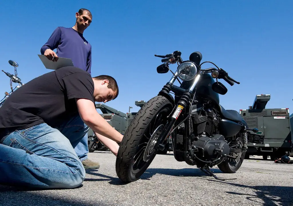 Person checking the tire pressure on their motorcycle